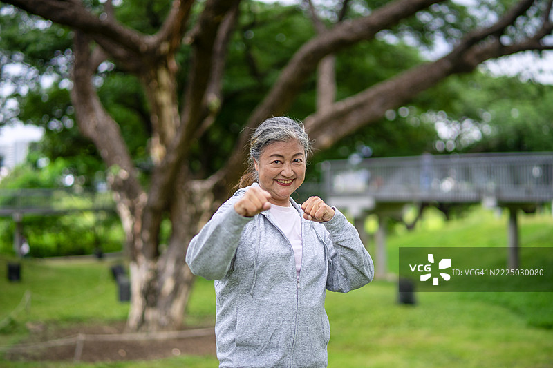 老年女性在公共公园锻炼。图片素材