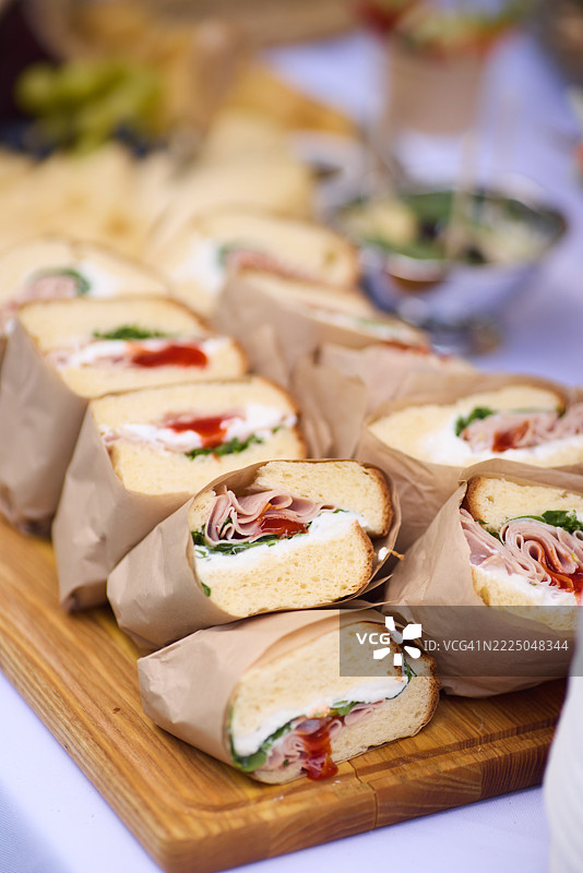 火腿奶酪三明治整齐地摆放在餐盘上，准备好招待派对客人。图片素材