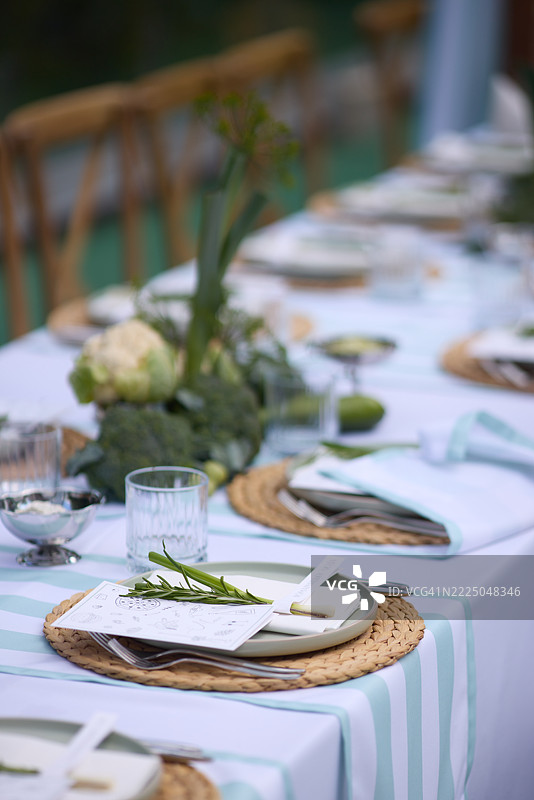 阳光明媚的地方，精美的餐具装饰着一张预留的桌子。图片素材