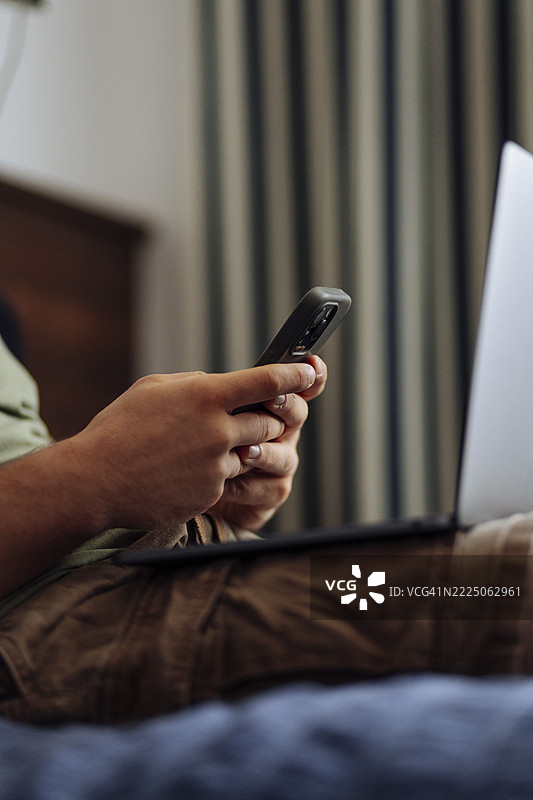 男子在笔记本电脑和智能手机上管理财务图片素材