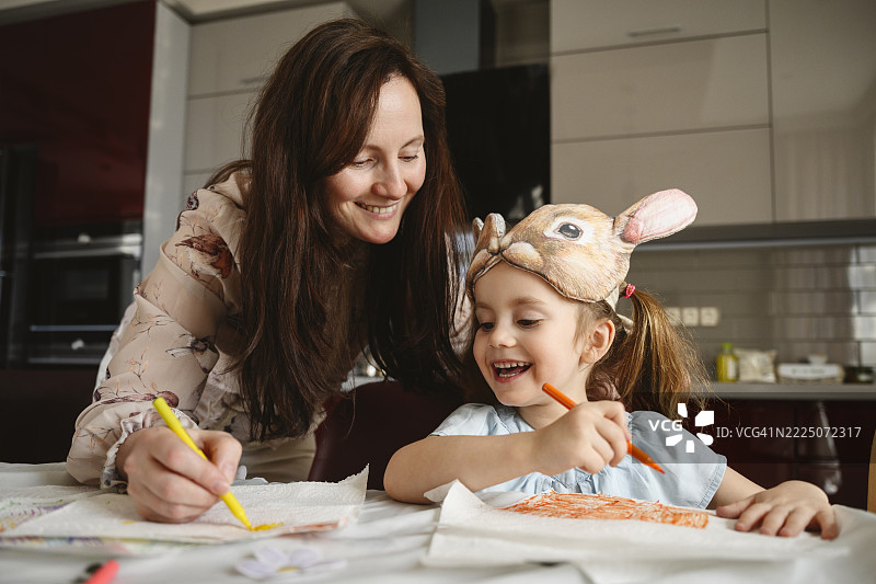 母亲和女儿在厨房里一起画画图片素材