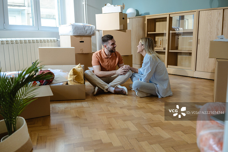 一对情侣在他们的新温馨公寓里享受 unpacking 的时光。图片素材