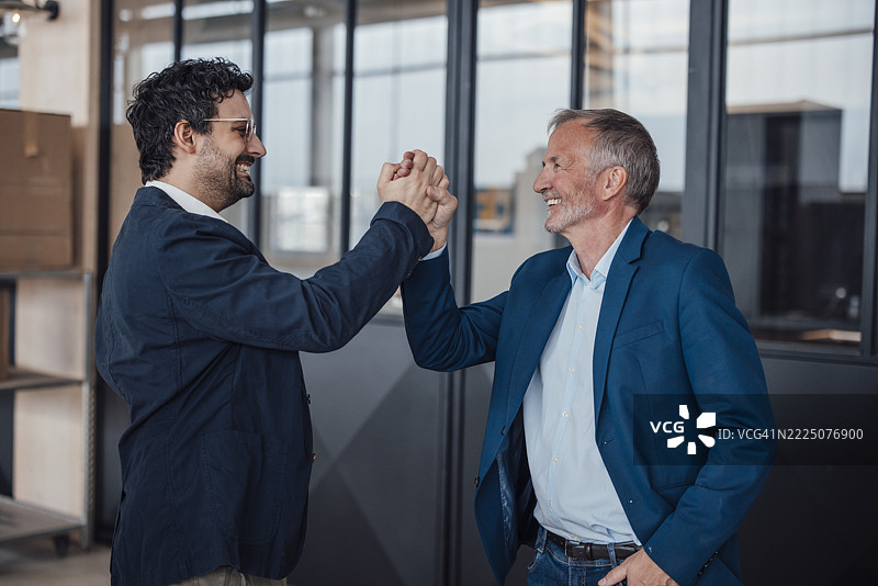 身穿商务正装的工程师在办公室环境中握手图片素材