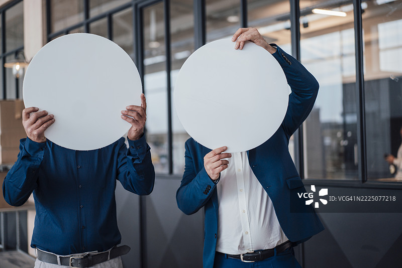 身穿商务正装的工程师在办公室环境中手持圆形物体图片素材