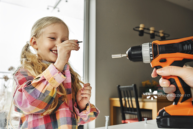 父亲和女儿在家一起组装家具图片素材