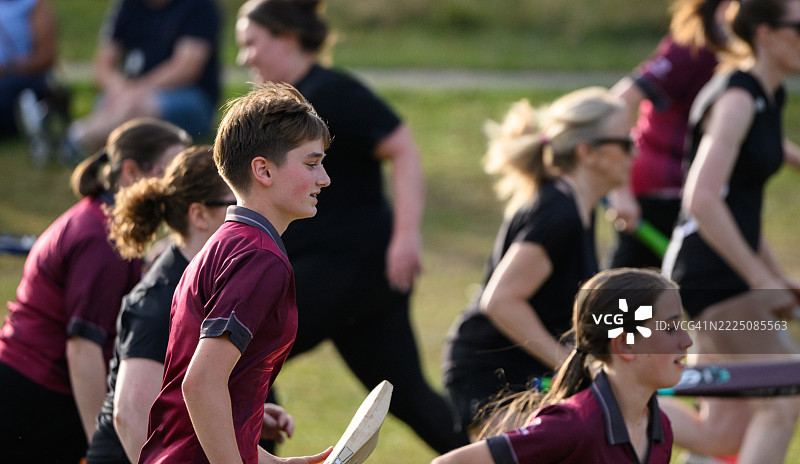 一群不同年龄的女性和女孩在练习时挥舞着板球棒奔跑图片素材