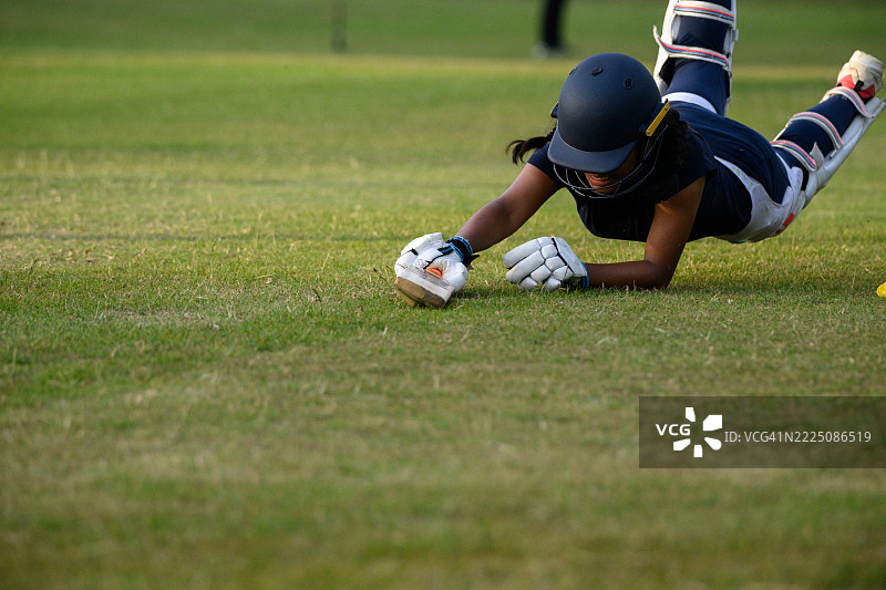 青少年女性板球击球手滑行扑倒以得分图片素材