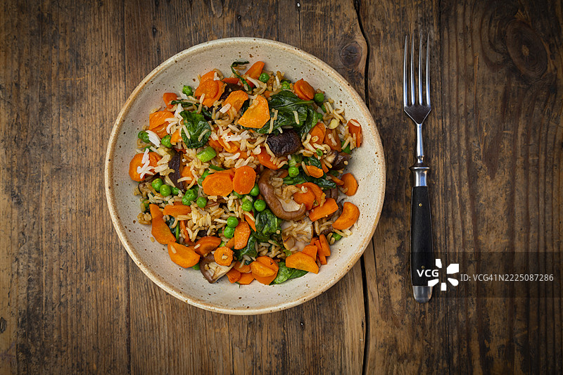 木桌上摆放着蔬菜和香菇炒饭图片素材