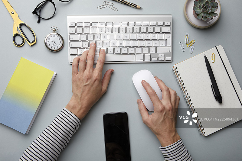 整洁的工作空间俯视图，配有键盘、鼠标和文具图片素材