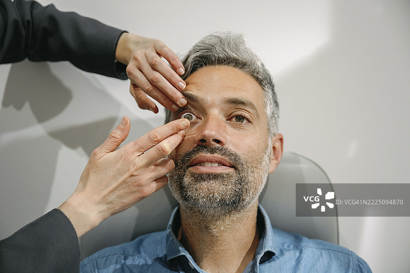 验光师在诊所帮助患者佩戴隐形眼镜图片素材