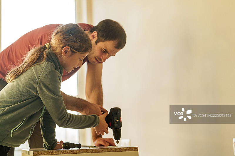 父亲教女儿组装家具图片素材