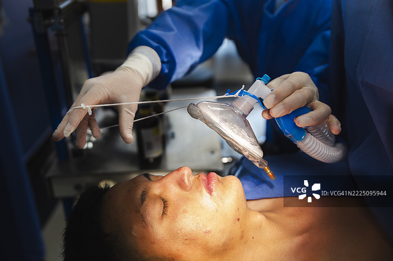 护士在手术室为患者戴上麻醉面罩图片素材