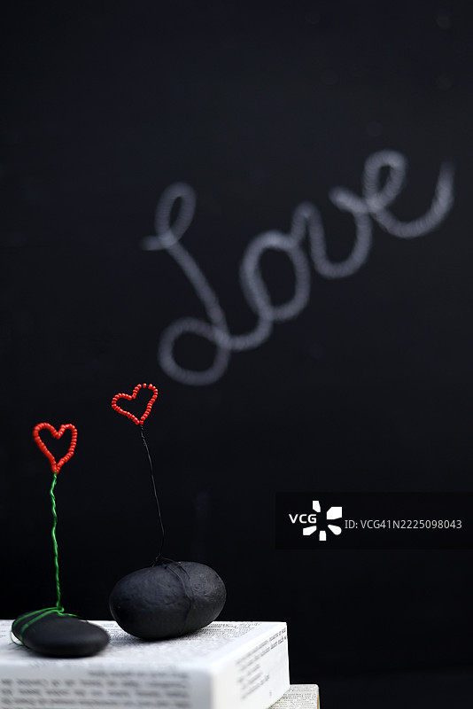 工作室环境中带有“爱”字的手工心形装饰品与黑板图片素材