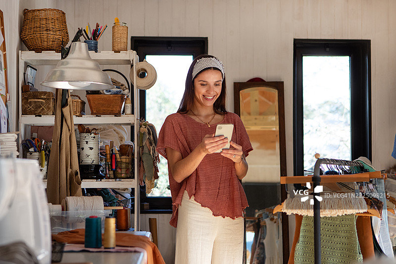 年轻女性纺织企业家在她的创意工作室里图片素材