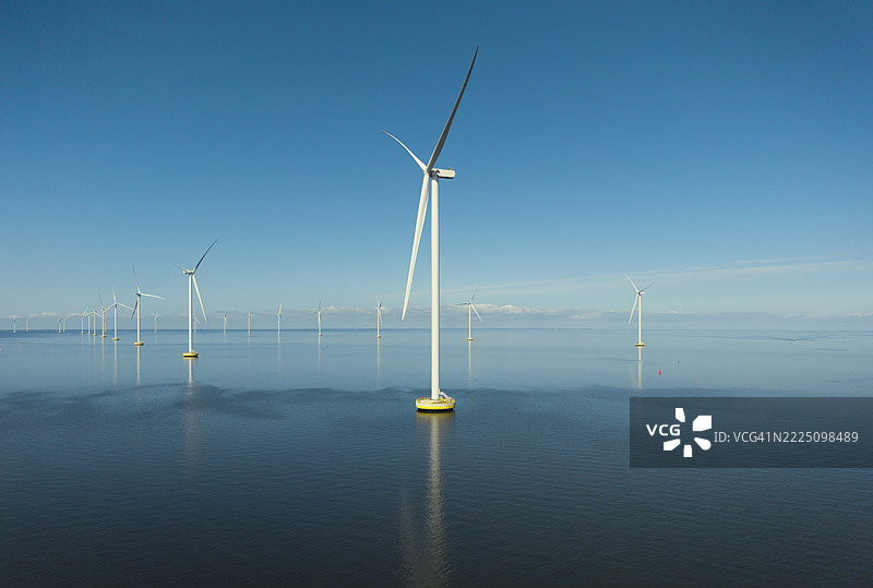 荷兰无风的日子里，海面平静，蓝天映衬下的海上风电场图片素材