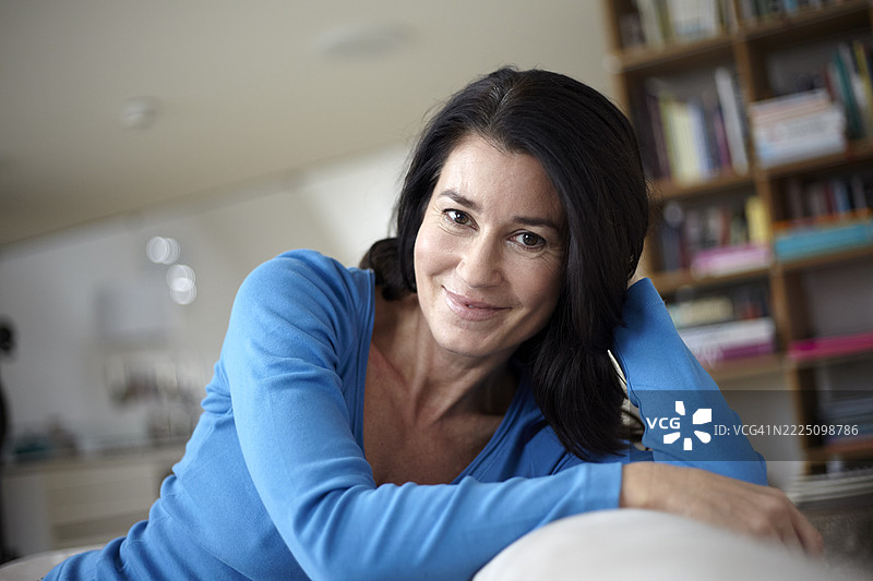 现代阁楼中放松的女性，微笑着看向镜头图片素材