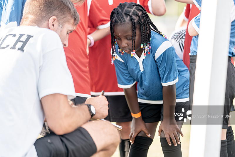 年轻足球教练在场上为球队提供指导图片素材