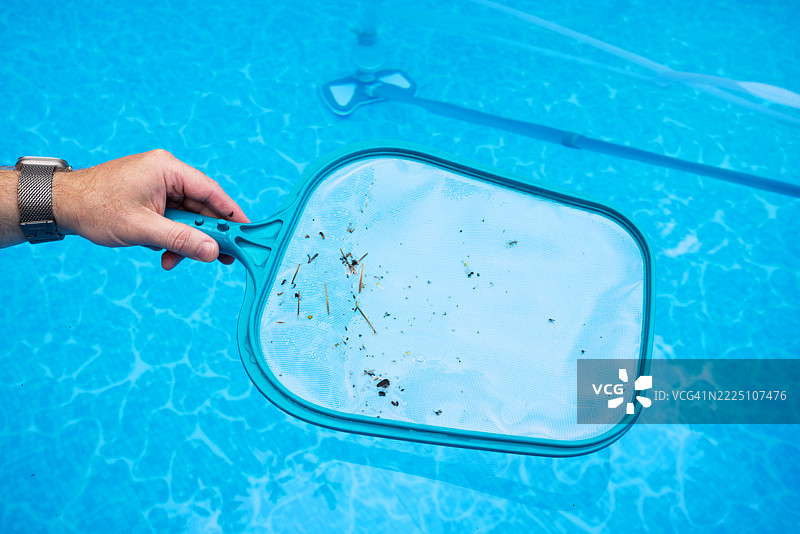 男子在清洁蓝色游泳池图片素材