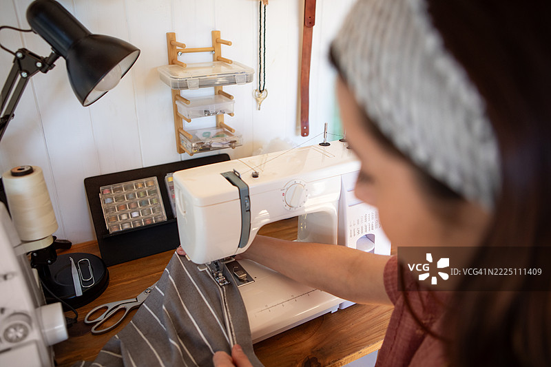 年轻女性纺织企业家在她的创意工作室里图片素材