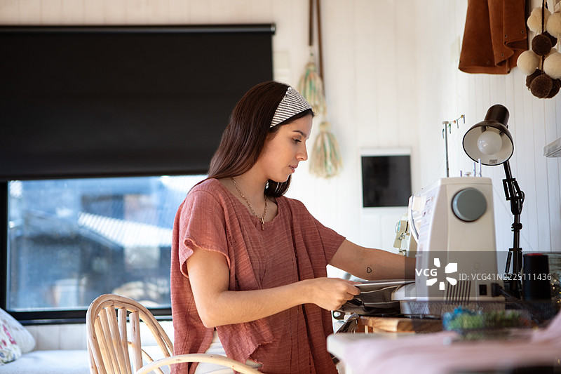 年轻女性纺织企业家在她的创意工作室里图片素材