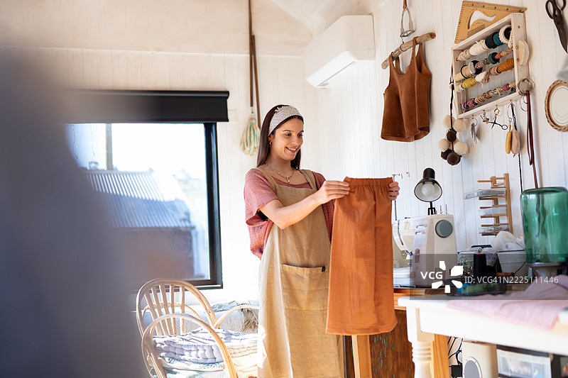 年轻女性纺织企业家在她的创意工作室里图片素材