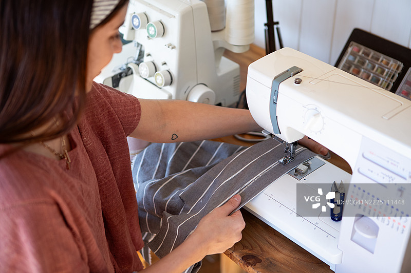 年轻女性纺织企业家在她的创意工作室里图片素材