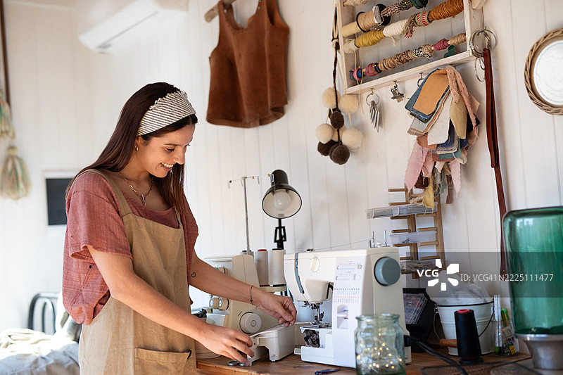 年轻女性纺织企业家在她的创意工作室里图片素材