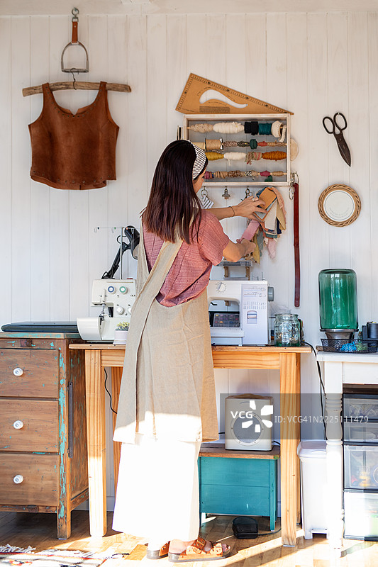 年轻女性纺织企业家在她的创意工作室里图片素材