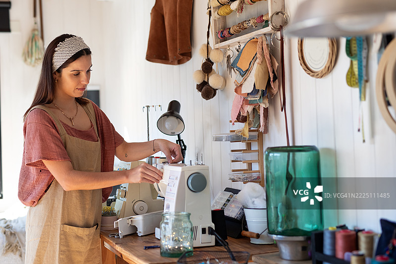 年轻女性纺织企业家在她的创意工作室里图片素材