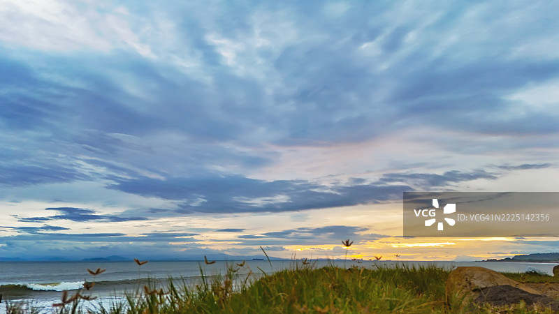 海岸线日落景观，海洋与草地海岸图片素材