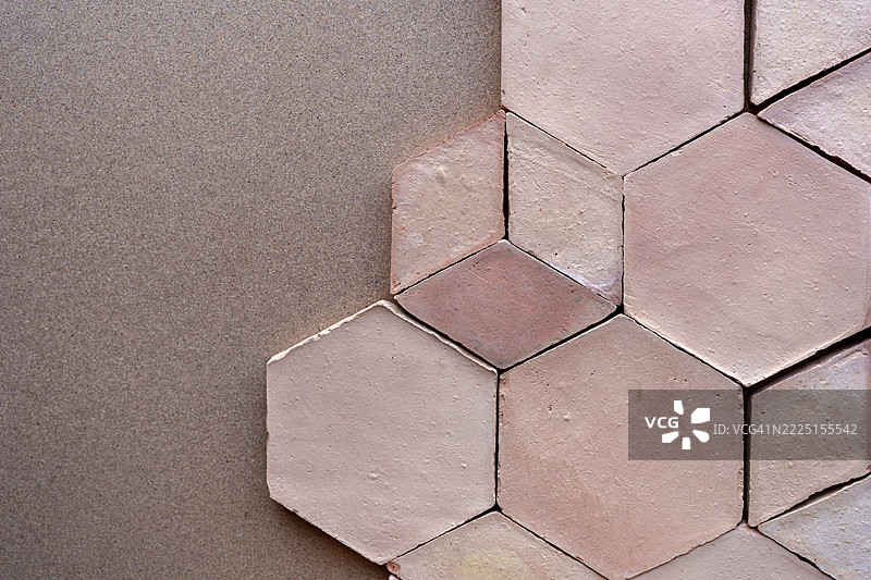 粉色六角形陶土瓷砖在棕色表面上形成几何图案图片素材