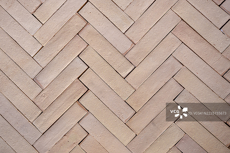 人字形图案形成的质感米色砖墙背景图片素材