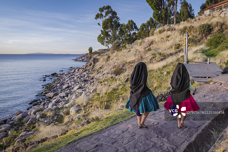 年轻女孩在秘鲁的的的喀喀湖塔基尔岛上手工纺羊毛图片素材