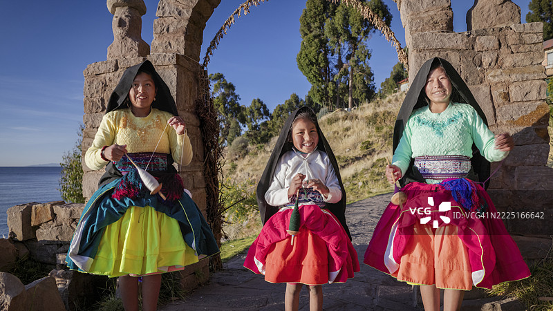 年轻女孩在秘鲁的的的喀喀湖塔基尔岛上手工纺羊毛图片素材