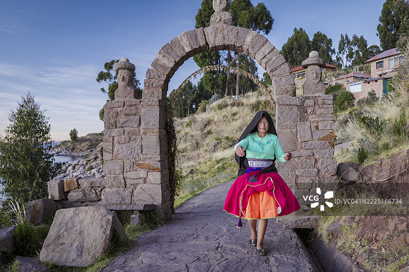 年轻女孩在秘鲁的的的喀喀湖塔基莱岛上手工纺羊毛图片素材