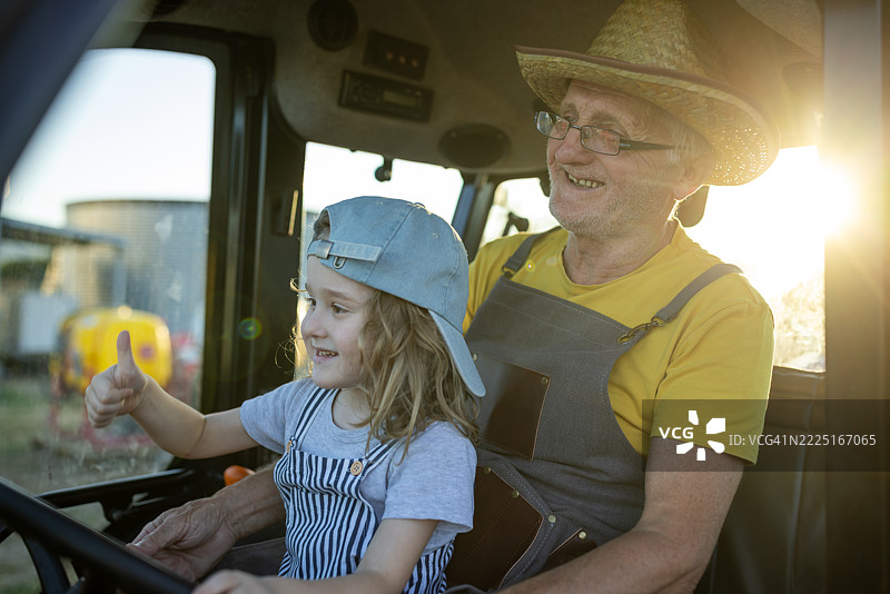 爷爷和孙子在有机农场的拖拉机上图片素材