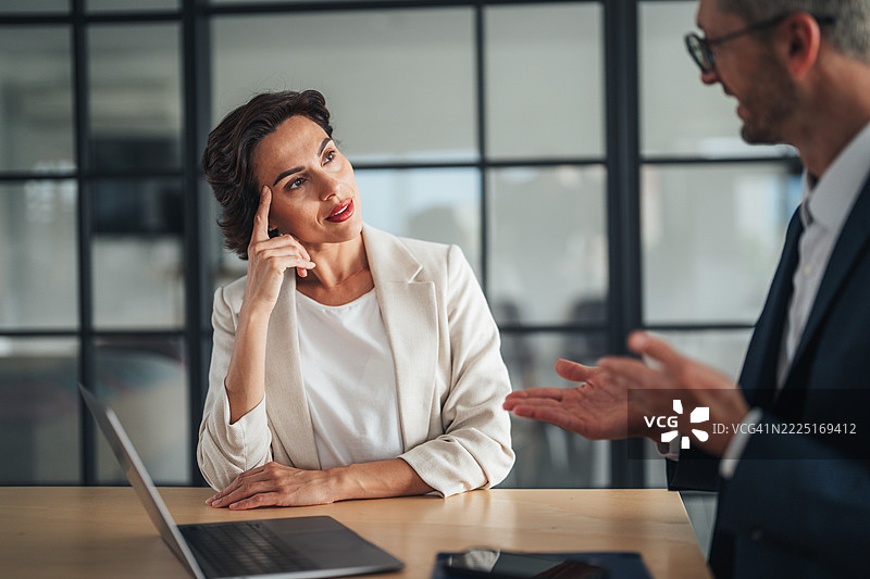 现代办公室环境中的专业商务讨论。女经理与同事讨论新项目。公司老板在办公室与员工开会。图片素材