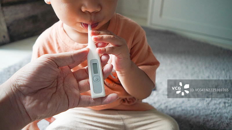 生病的混血幼儿正在测量体温图片素材