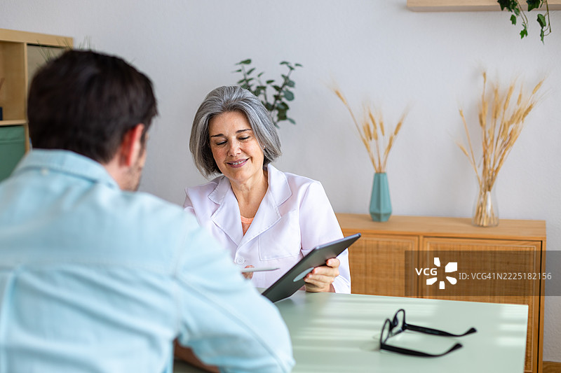女医生向患者展示平板电脑上的检测结果图片素材