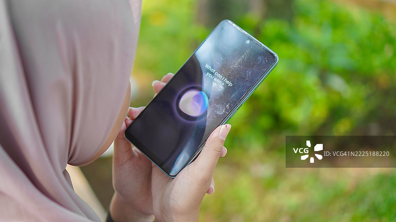 穆斯林女性在智能手机上使用语音助手图片素材