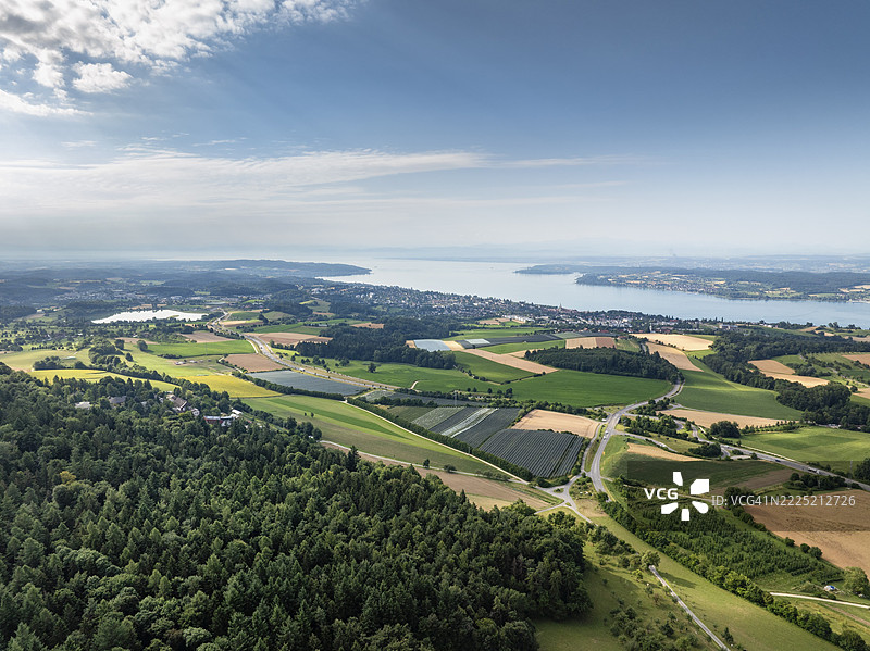 德国巴登-符腾堡州博登湖区于乌贝林根的航拍图，展示成熟的谷物田和带有防雹保护的果园。图片素材