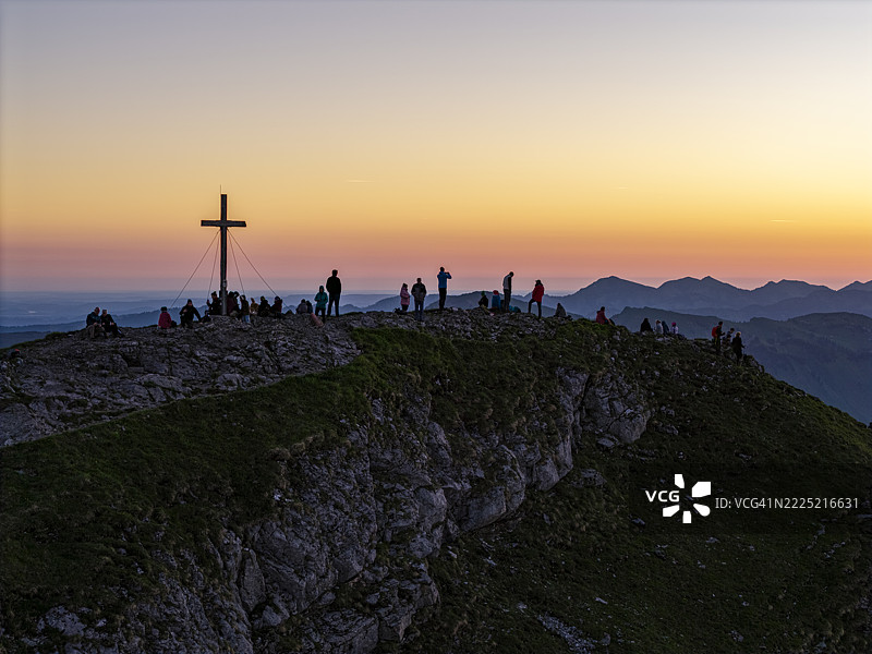 日出时分山顶上的徒步旅行者剪影图片素材