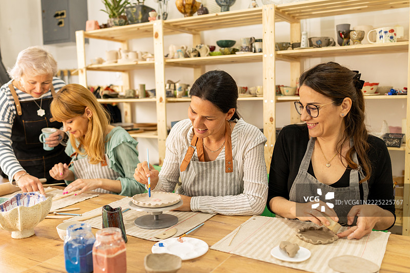 陶艺班讲师在工作坊与女学生一起学习图片素材