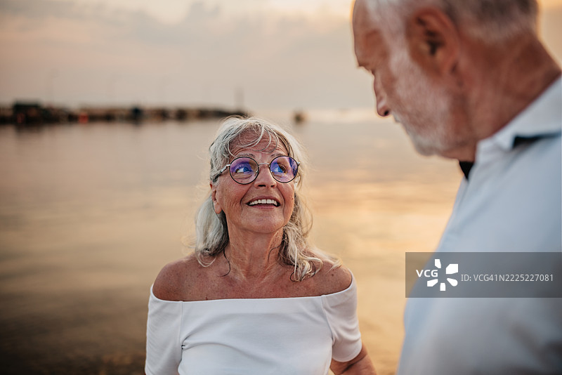 老年夫妇在夏季假期中享受海边浪漫时刻，拥抱爱情与幸福图片素材