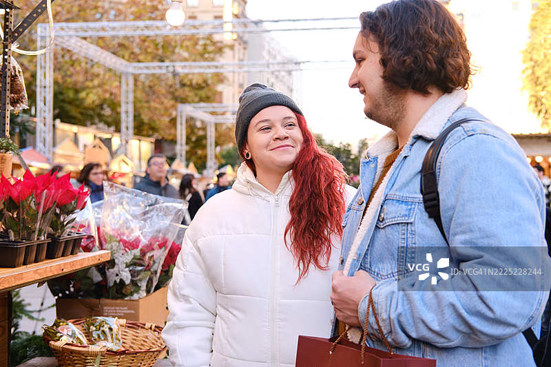 年轻情侣在巴塞罗那市场购买圣诞花卉图片素材