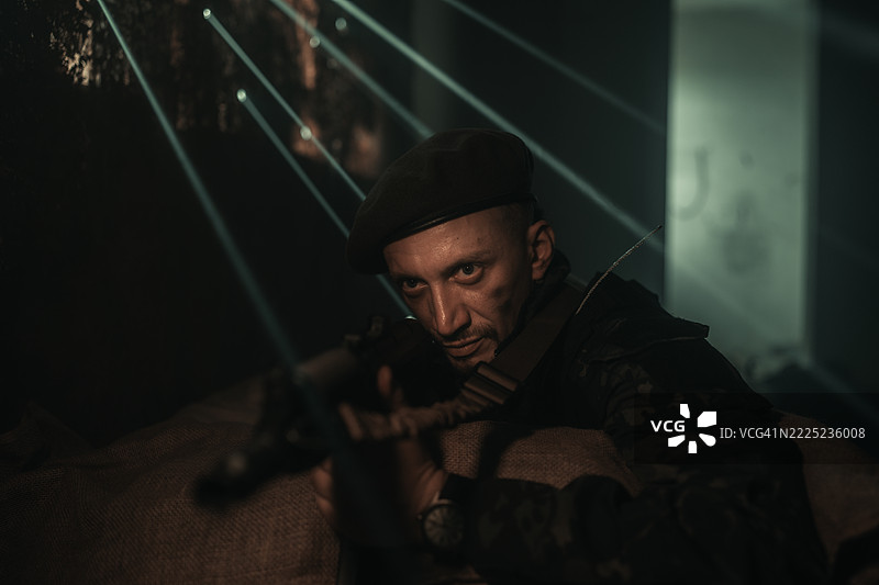 在戏剧性灯光下摆姿势的贝雷帽战术士兵图片素材