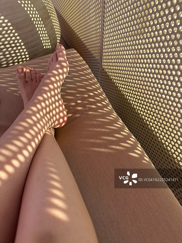 女人放松地坐在沙发上的下半身图片素材