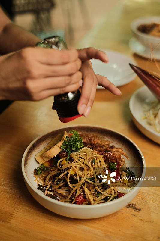女人的手在桌子上拍摄碗里的食物图片素材