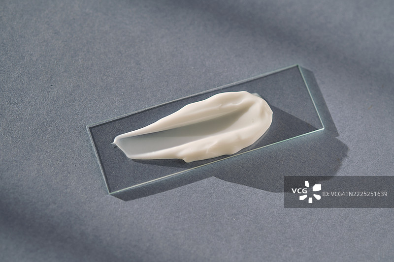 蓝色背景上的白色奶油涂抹在幻灯片上图片素材