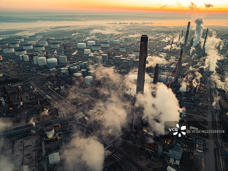 福利炼油厂在日落时分冒出烟雾和蒸汽的鸟瞰图图片素材